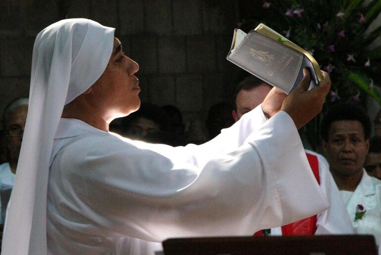 Sr Kalolaine CSN, a Tongan nun working at St. Christopher's Home in Suva, bears the Bible for the reading of the Gospel.