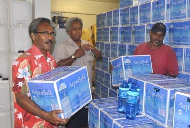 DoP staff Tome Enikosuna (left), Sione Makisiale and Mesake Saneger stack water at the Tuvalu High Commission in Suva.