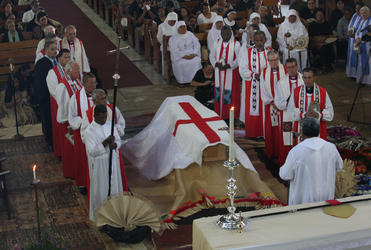 The Dean of Suva invites mourners to file past the coffin of Archbishop Bryce