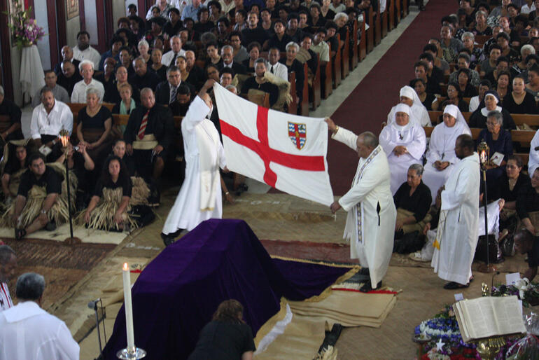 The diocesan flag about to be draped across the casket.