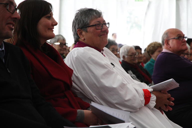 Bishop Waitohiariki smiles in response to Dr Jenny Te Paa Daniel's words, as she sits flanked by whanau.