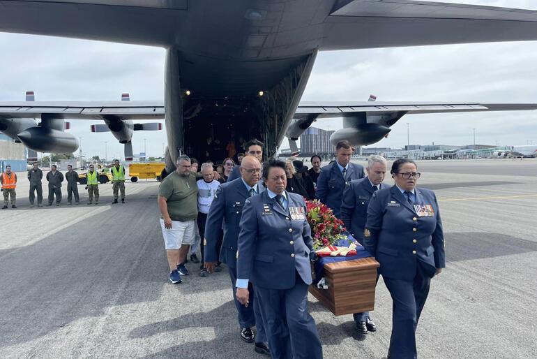 Air Force personnel carry Bishop Richard Wallace's coffin from the Hercules aircraft which returned him to Ōtautahi.