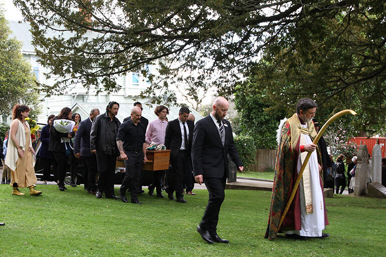 Archbishop Philip leads the sons and grandsons of Archdeacon Tiki as they bear him on to St Mary's.