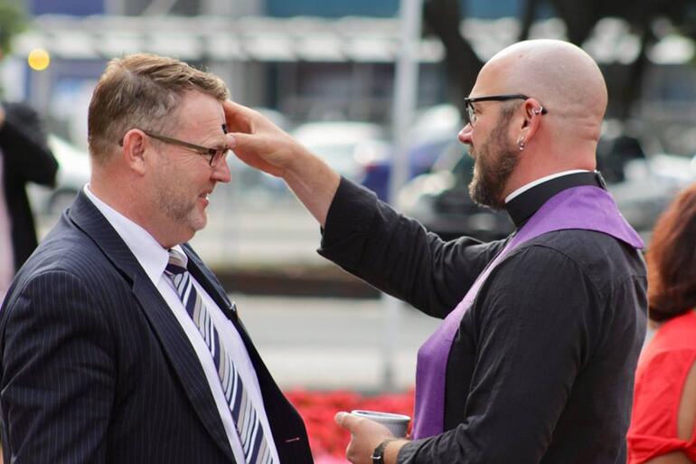 Rev Joe McGarry imposes ashes on one of the dozens who took up the offer of ashes to go today.