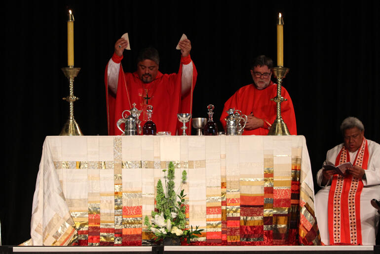Archbishop Don Tamihere breaks the bread.