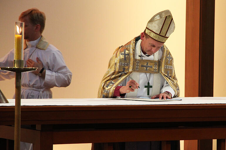 Bishop Ross Bay signs the Consecration Charter on the high altar.