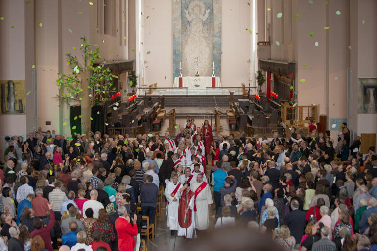 Newly ordained at Wellington Cathedral depart as leaves from the 'tree of life' shower prayers over the congregation. Photo: John Setter