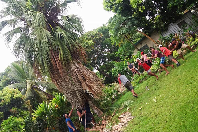 Young people from All Saints topple a tree which had been made dangerous by Gita. Young people from All Saints topple a tree which had been made dangerous by Gita.
