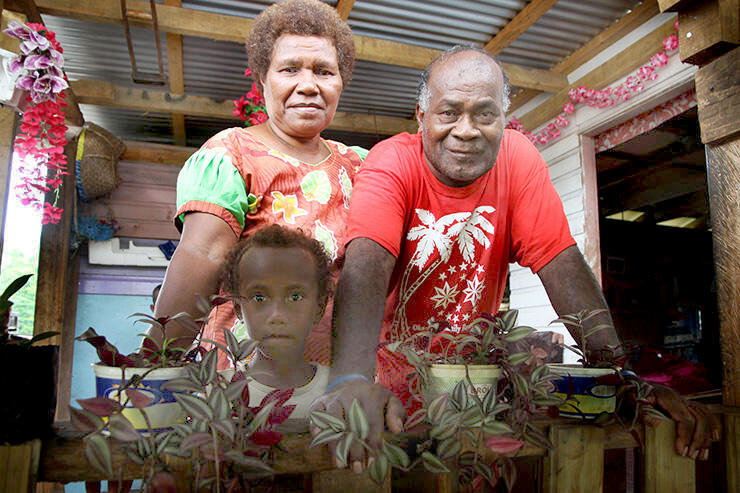 Peni and Vilomena Waqamaira and their grandson at home - their new home - in Maniava.