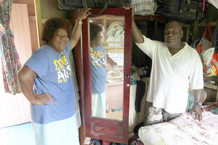 This couple pose by the wardrobe in which they, and two of their children, rode out Cyclone Winston.