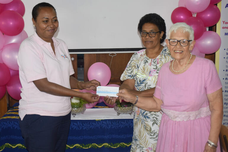 Mrs Esita Vuki and Mrs Marie Lee present $1630.00 to a Fiji Cancer Society representative during 'PInktober' 2023.
