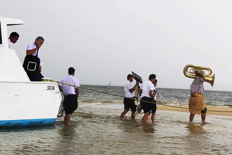 The St Andrews High School brass band disembarks on the sandbank.