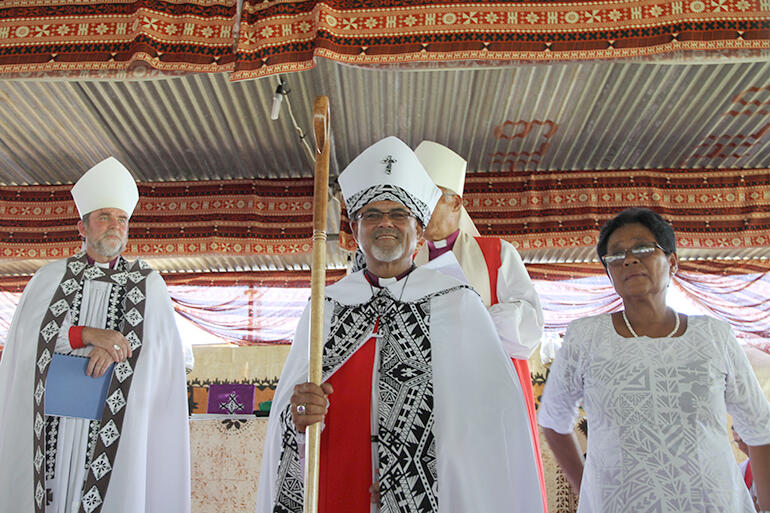 The new bishop is presented to his people - at the right of the photo is Bishop Henry's wife, Alumita.