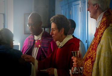 Presiding Bishop Jefferts Schori gives communion during the Episcopal service of repentance.