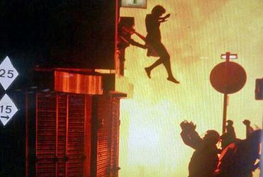 A woman jumps into the arms of police during the London riots.