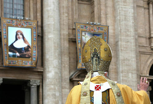 Mary MacKillop watches from on high as the Pope arrives to canonise her.