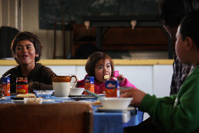 Tiaki Edwards tackles her breakfast banana and bacon on toast. That's her brother Daerell at left.