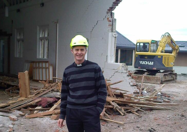 General Secretary Michael Hughes amid the rubble of the chapel at Churchill Courts in the suburb of Shirley.