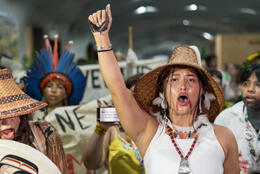 Indigenous person with painted face shouts in Brazilian COP climate rally