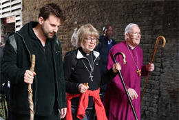 Sarah Mullally walks as a pilgrim flanked by a male priest and bishop