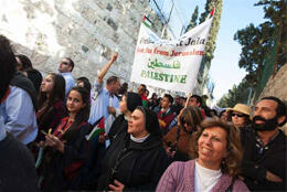 Marchers including nuns and Palestinian women without headscarves walk with Palestine flags and parish flags