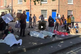 Protestors hold up placards calling for genocide in Gaza to be named and lie under shrouds on the footpath outside York Minster where the Church of England's General Synod is meeting