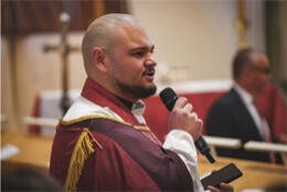 Archdeacon Zhane speaks into a microphone