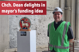 Dean Ben Truman in a hard hat and hi-vis vest inside the shell of Christchurch Cathedral