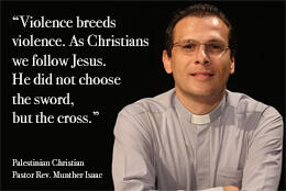 Palestinian Pastor in a grey clerical shirt smiles against a black background