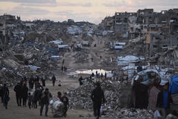 People walk in Gaza's grey streets lined with the rubble of concrete apartment buildings
