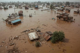 Half submerged homes sit in brown floodwaters