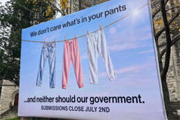 A billboard features a clothesline with three pairs of jeans in pink and blue