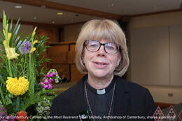 Archbishop of Canterbury Sarah Mullally smiles beside a floral arrangement in Canterbury