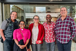 Five bishops stand in front of a door in informal dress