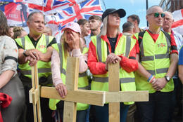 Right-wing UK protestors stand with Union jacks and wooden crosses