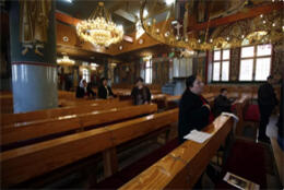 A richly decorated Orthodox church interior seats a small number of Palestinians Christians