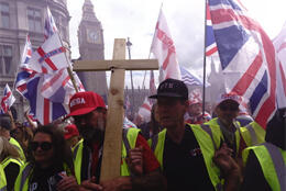 Marchers link arms as Union Jack flags wave in front of the UK Houses of Parliament