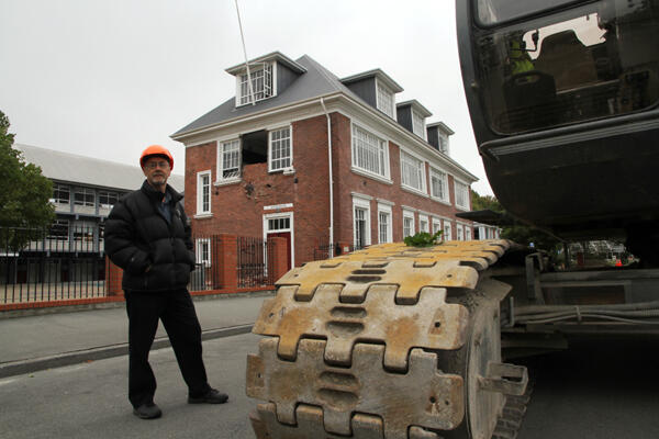 Malcolm Long, acting Headmaster at Christchurch's Cathedral Grammar School, in front of the damaged Statham Building.