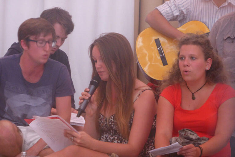 Rachel Smith (with microphone) leads worship during the Taize service. 