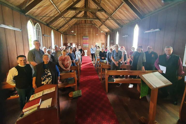 (L)Rev Cruz Karauti-Fox and (R)Archbishop David Moxon flank pilgrims at St Paul's Rangiaowhia, one of the 2023 Anglo-Catholic Hui pilgrimage sites.