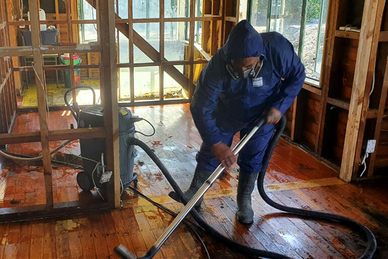 A man uses one of the industrial wet materials vacuum cleaners that Ngāti Kahungungu Iwi provided to whānau.