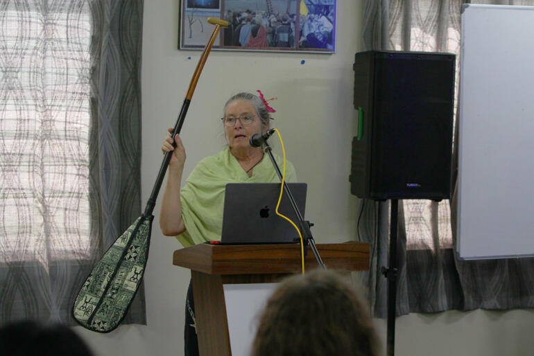 Professor Beth Holland raises a paddle as a measure to illustrate the increasing volume of sea level rise under the latest projections.