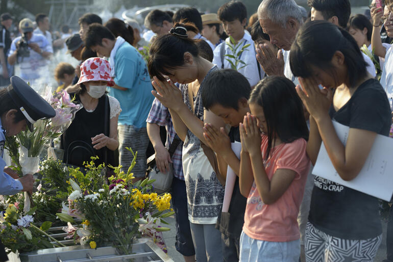 Japanese students pray in Hiroshima near the epicentre of the nuclear bomb that killed thousands on 6 August 1945. Photo: WCC/Paul Jeffrey. Japanese students pray in Hiroshima near the epicentre of the nuclear bomb that killed thousands on 6 August 1945. Photo: WCC/Paul Jeffrey.