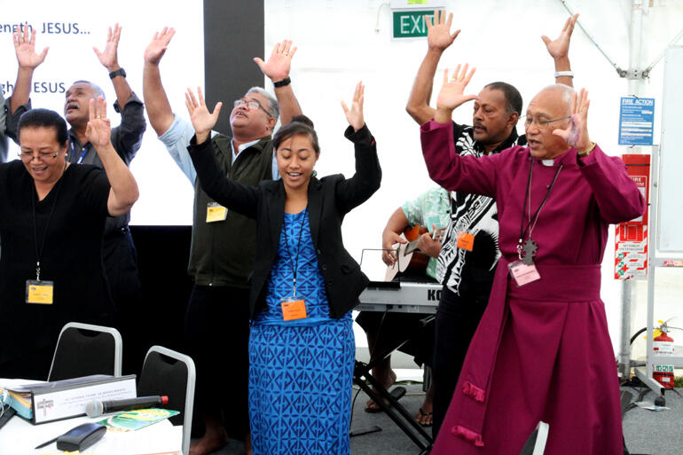 From left: Evelingi Langi and Rosa Filoi dance in support of Archbishop Winston.