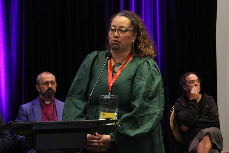 Te Waipounamu delegate Susan Wallace chairs Synod in committee as Bishop Andrew Hedge and Bishop Justin Duckworth look on.