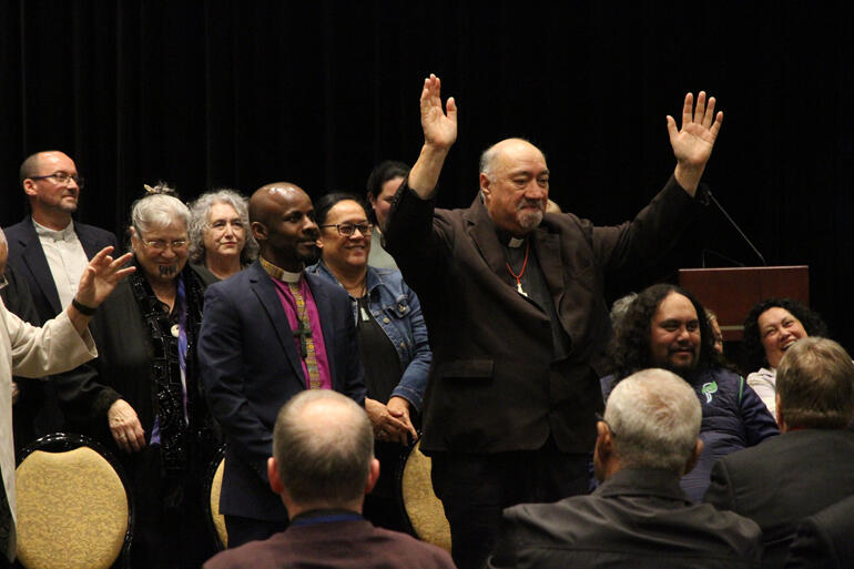 Archdeacon Harvey Ruru invites General Synod Te Hīnota Whānui to raise their hands in a Covid friendly greeting to conclude the Mihi Whakatau. Archdeacon Harvey Ruru invites General Synod Te Hīnota Whānui to raise their hands in a Covid friendly greeting to conclude the Mihi Whakatau.