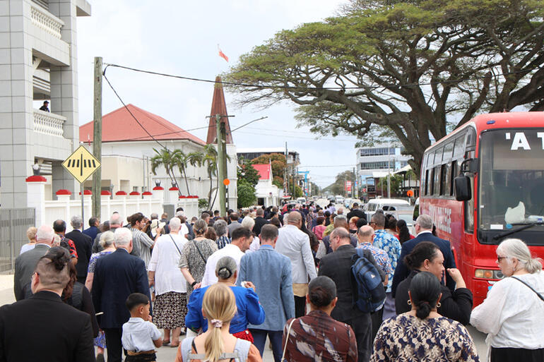 Traffic pauses as the Anglican visitors process to the Palace.