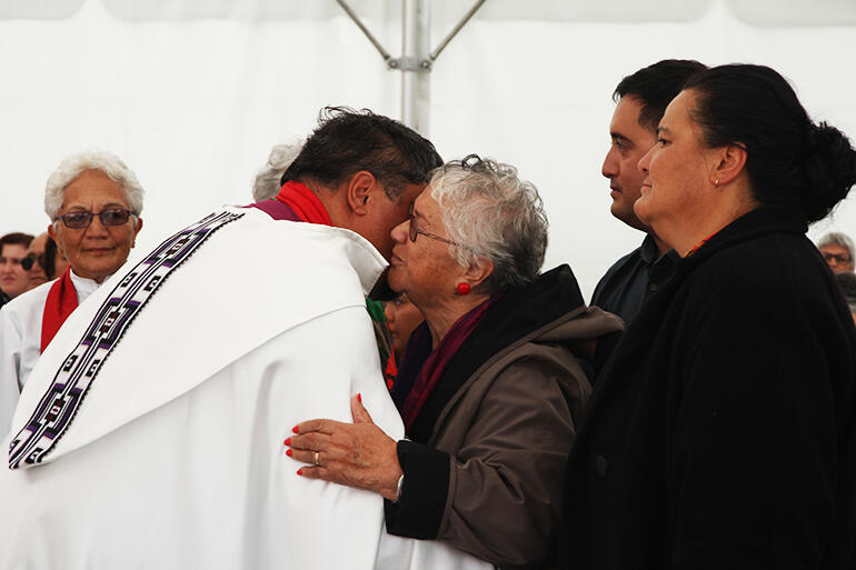 Whaea Mihi blesses the new bishop of Te Tairawhiti, with her daughter Jan and grandson Nehe in support. Whaea Mihi blesses the new bishop of Te Tairawhiti, with her daughter Jan and grandson Nehe in support.