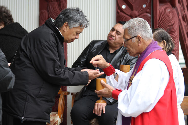 Bishop Ngarahu Katene serves the Eucharist wafer to Lorraine Toki. Bishop Ngarahu Katene serves the Eucharist wafer to Lorraine Toki.