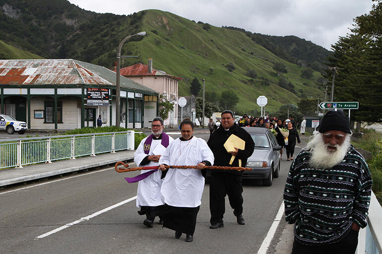 Jackie Chesley-Ingle is carrying Bishop John's Waipounamu crozier - while Tapu Laulu is holdinghis mitre.